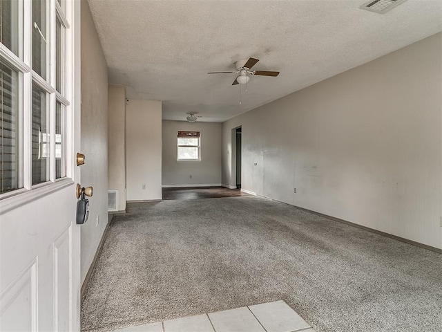 carpeted empty room with a textured ceiling and ceiling fan