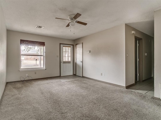 carpeted spare room featuring a textured ceiling and ceiling fan