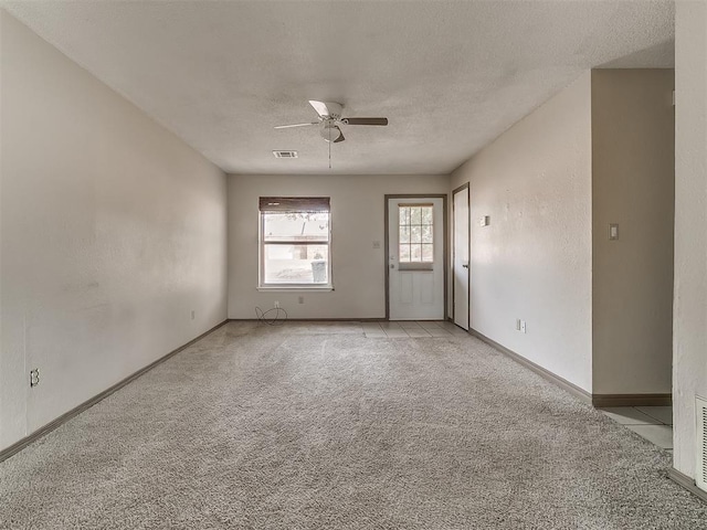 carpeted spare room featuring ceiling fan and a textured ceiling