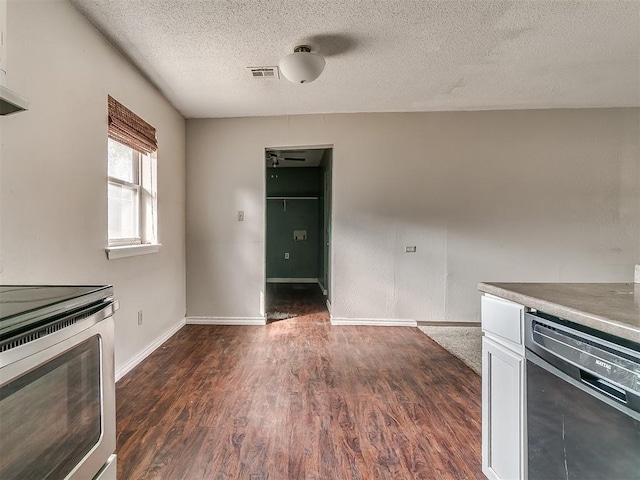 kitchen featuring dishwasher, dark wood-type flooring, white cabinets, stainless steel stove, and a textured ceiling