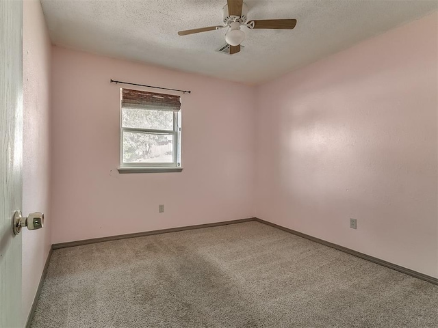 carpeted spare room with a textured ceiling and ceiling fan