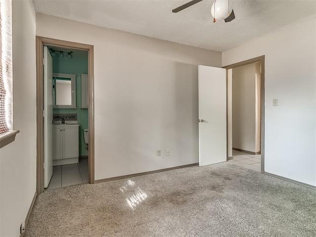 carpeted spare room with ceiling fan and a textured ceiling