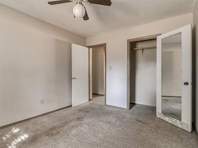 unfurnished bedroom featuring ceiling fan, a closet, light colored carpet, and a textured ceiling