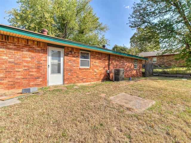 rear view of house with a lawn and central AC unit