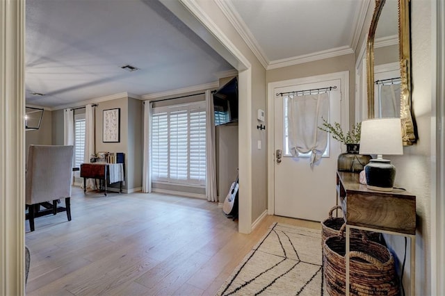 foyer entrance featuring crown molding and light hardwood / wood-style flooring