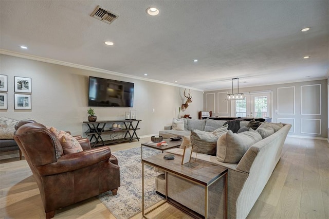 living room with light hardwood / wood-style flooring and ornamental molding