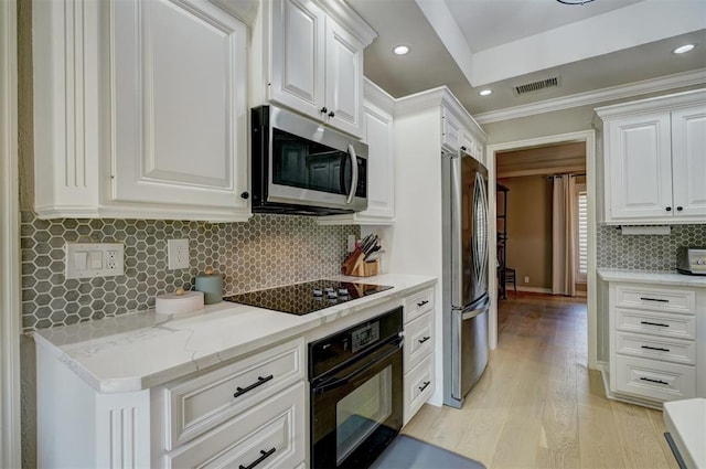 kitchen with light stone countertops, backsplash, black appliances, light hardwood / wood-style flooring, and white cabinetry