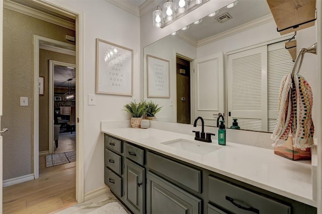 bathroom with crown molding, vanity, and wood-type flooring