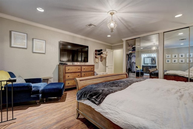 bedroom featuring wood-type flooring, crown molding, and a closet