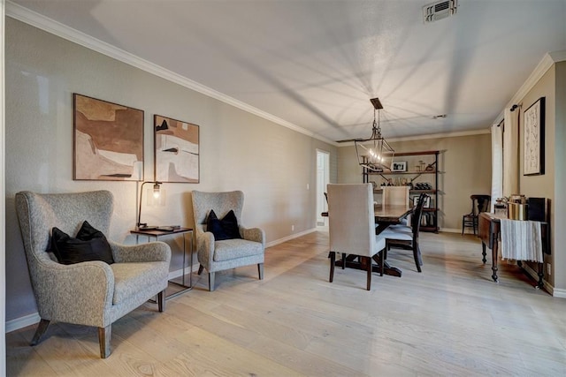 dining space with light hardwood / wood-style floors, a notable chandelier, and ornamental molding