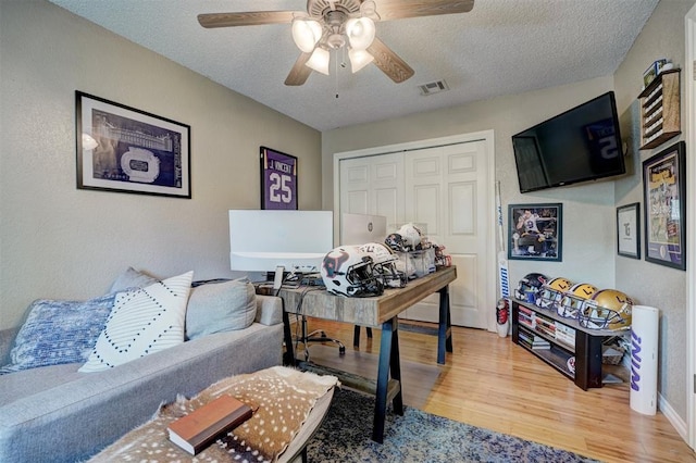 office area featuring ceiling fan, hardwood / wood-style floors, and a textured ceiling