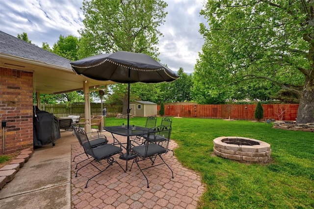 view of patio / terrace featuring a fire pit, area for grilling, and a storage shed