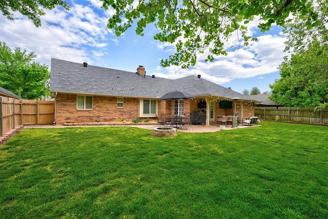 back of house featuring a yard, an outdoor fire pit, and a patio area