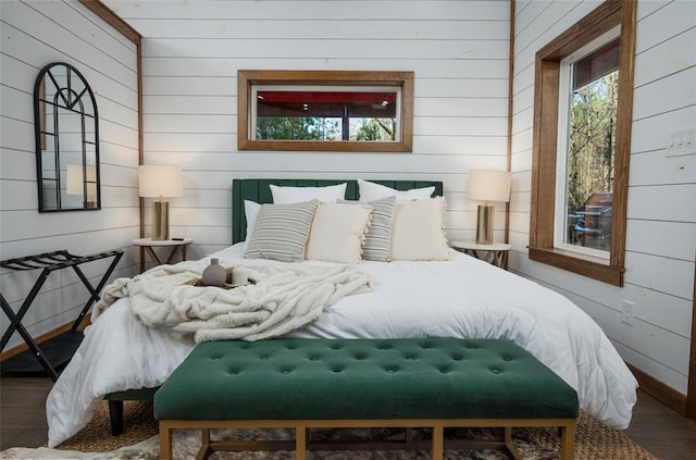 bedroom featuring hardwood / wood-style flooring and wood walls