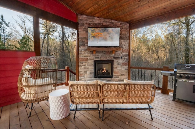 deck with an outdoor living space with a fireplace and grilling area