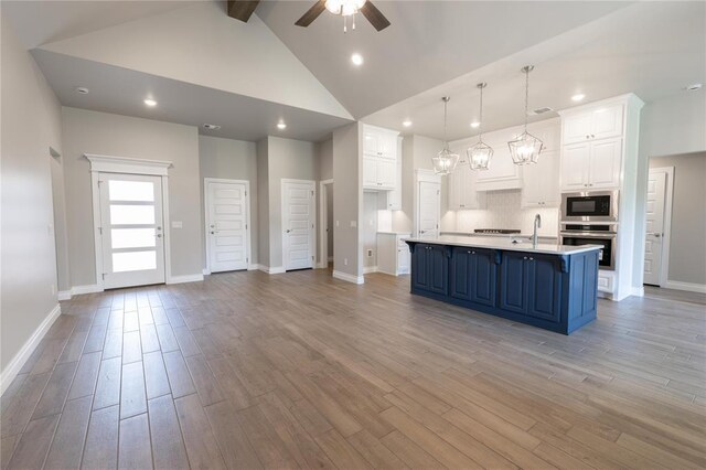 16025 Coneflower Dr, Edmond, OK 73013 - kitchen with oven, a ceiling fan, white cabinetry, light countertops, and blue cabinetry