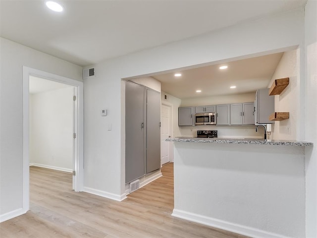 kitchen with gray cabinetry, light hardwood / wood-style floors, black electric range oven, and kitchen peninsula