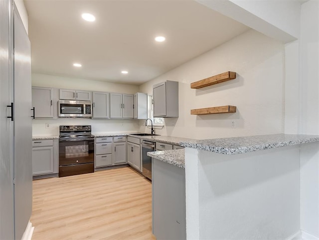 kitchen featuring gray cabinetry, sink, light wood-type flooring, appliances with stainless steel finishes, and kitchen peninsula