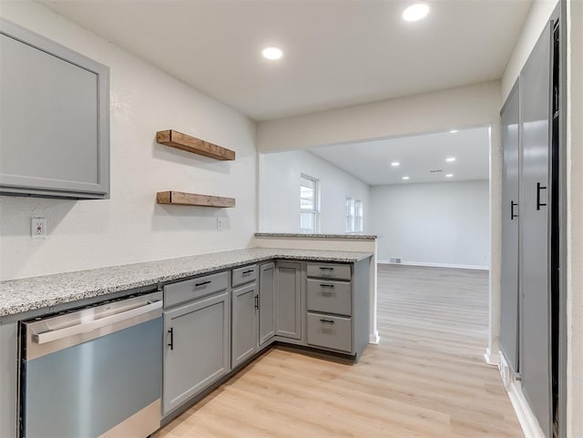 kitchen featuring gray cabinetry, light stone countertops, dishwasher, and light wood-type flooring