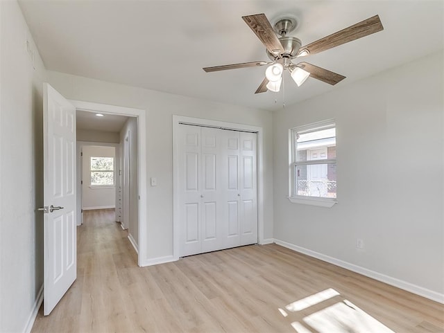 unfurnished bedroom with ceiling fan, light hardwood / wood-style flooring, and multiple windows