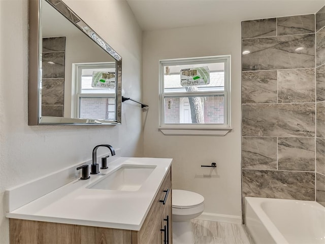 full bathroom with tiled shower / bath, vanity, and toilet