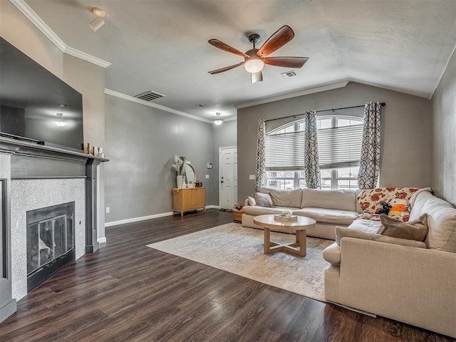 living room with a tiled fireplace, dark hardwood / wood-style floors, ornamental molding, and vaulted ceiling