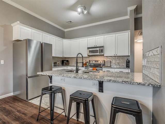 kitchen featuring light stone counters, white cabinetry, and stainless steel appliances