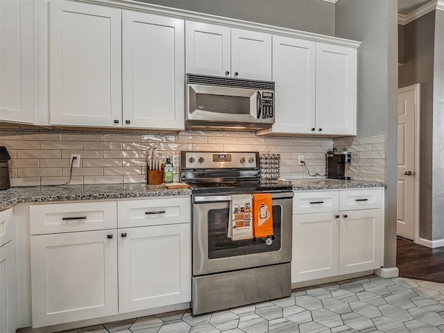 kitchen with white cabinetry, stainless steel appliances, tasteful backsplash, light tile patterned flooring, and light stone counters