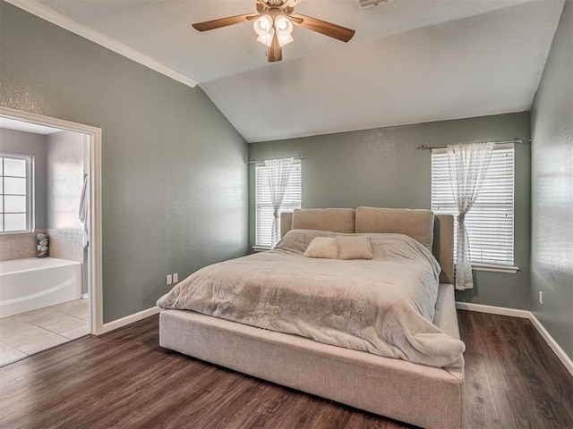 bedroom with ceiling fan, lofted ceiling, ensuite bathroom, and hardwood / wood-style flooring