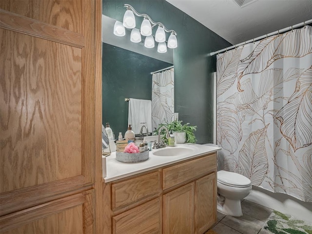 bathroom with toilet, vanity, and tile patterned flooring