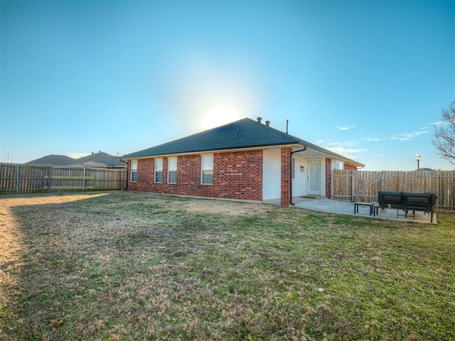 rear view of property with a yard and a patio