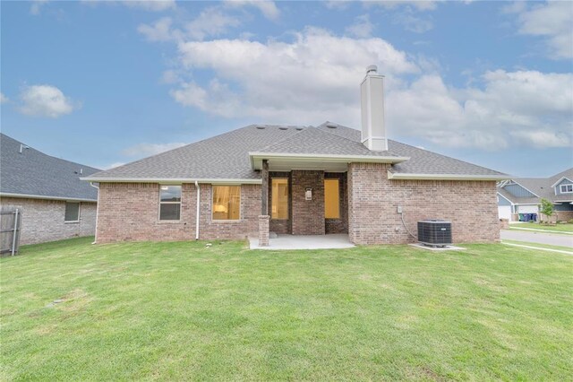 9201 Lupine Rd, Yukon, OK 73099 - back of property featuring a chimney, brick siding, a patio, and a lawn