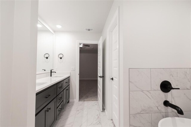9201 Lupine Rd, Yukon, OK 73099 - full bathroom featuring double vanity, marble look tile flooring, a freestanding tub, recessed lighting, and baseboards