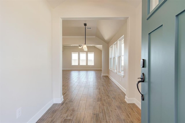 interior space with ceiling fan, lofted ceiling, and light hardwood / wood-style floors