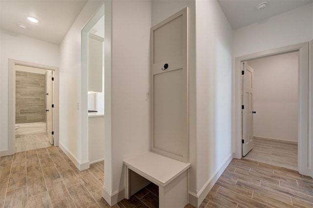 mudroom featuring wood tiled floor and baseboards