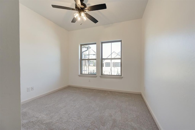 spare room with light carpet, ceiling fan, and baseboards