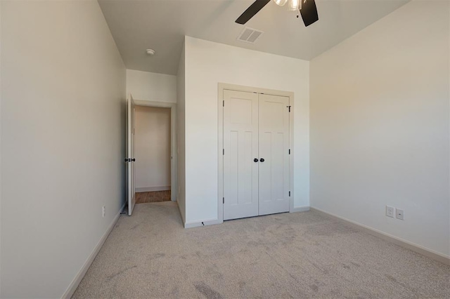 unfurnished bedroom featuring a closet, visible vents, light carpet, and baseboards