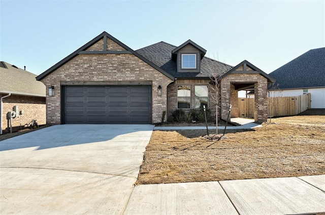 craftsman inspired home with driveway, a garage, roof with shingles, fence, and brick siding