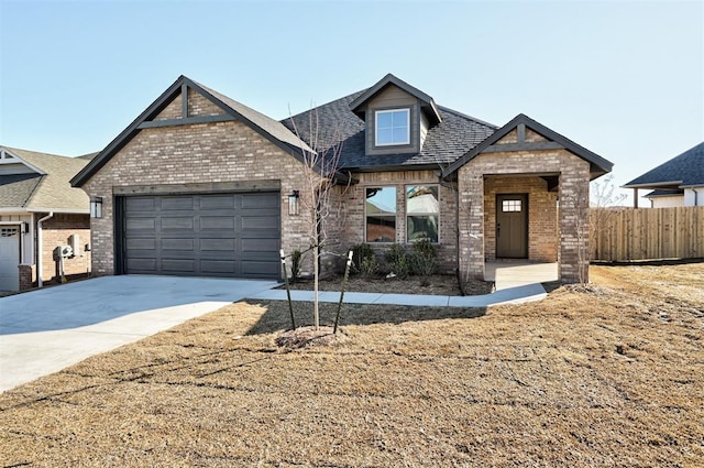 craftsman house with concrete driveway, brick siding, fence, and an attached garage