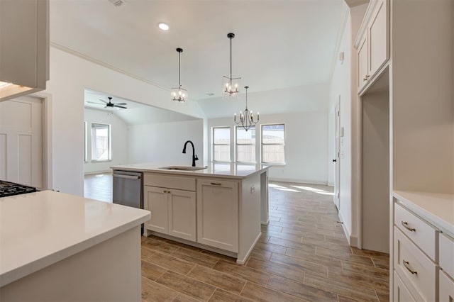 kitchen featuring light countertops, a sink, hanging light fixtures, and stainless steel dishwasher