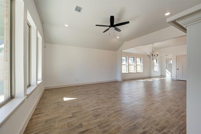 empty room with visible vents, baseboards, wood tiled floor, vaulted ceiling, and ceiling fan with notable chandelier