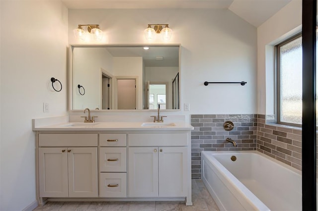 full bathroom with lofted ceiling, a garden tub, a sink, and double vanity