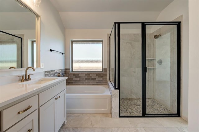 bathroom featuring a stall shower, a garden tub, and vanity