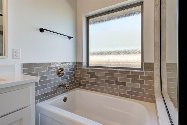 bathroom with a garden tub and vanity