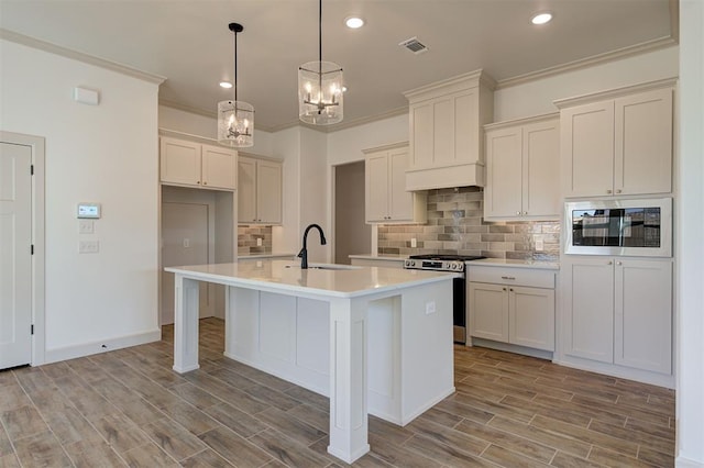 2216 Los Angeles Ave, Edmond, OK 73034 - kitchen with gas range, built in microwave, a sink, a chandelier, and an island with sink