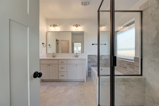 2216 Los Angeles Ave, Edmond, OK 73034 - full bath with a garden tub, double vanity, marble look tile flooring, and a shower with door