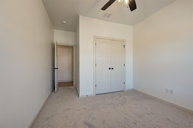 2216 Los Angeles Ave, Edmond, OK 73034 - unfurnished bedroom featuring light colored carpet, baseboards, a closet, and ceiling fan