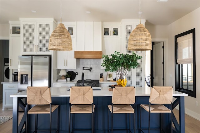 kitchen featuring decorative light fixtures, wood-type flooring, white cabinetry, and stainless steel refrigerator with ice dispenser