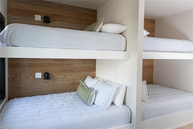 bedroom featuring wood walls