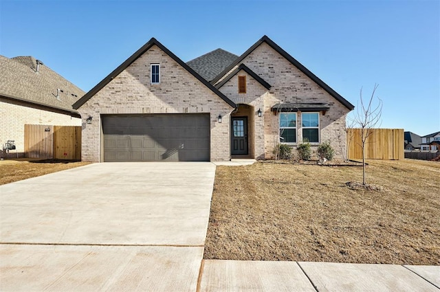 french country inspired facade featuring concrete driveway, brick siding, an attached garage, and fence